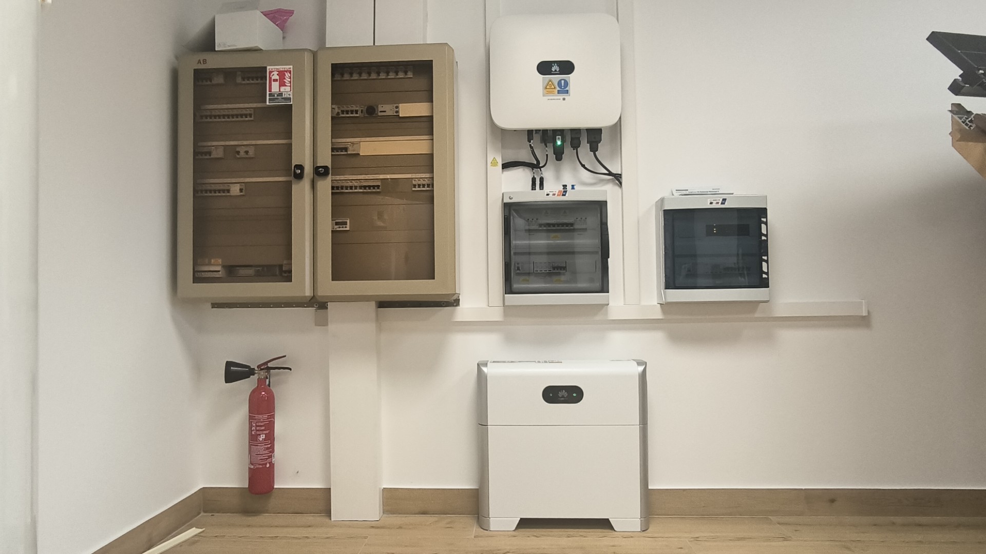 Installation photovoltaïque Dans les locaux de mon installateur solaire on voit un onduleur de la marque Hu Avec une batterie de la marque Huawei et un tableau électrique Un extincteur est situé à côté
